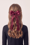 Burgundy bow hair clip worn in the hair, long tails – back view