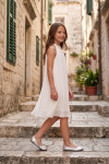 Rozalia girls' white pleated dress outdoors on steps – side view
