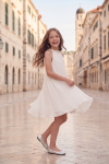 Rozalia white pleated dress in an old town square – twirling