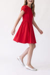 Rumi red dress – flared skirt in motion, framed to the feet