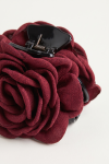 Burgundy fabric rose on a black claw clip – close-up