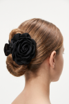 Black rose claw clip holding a low bun – back view